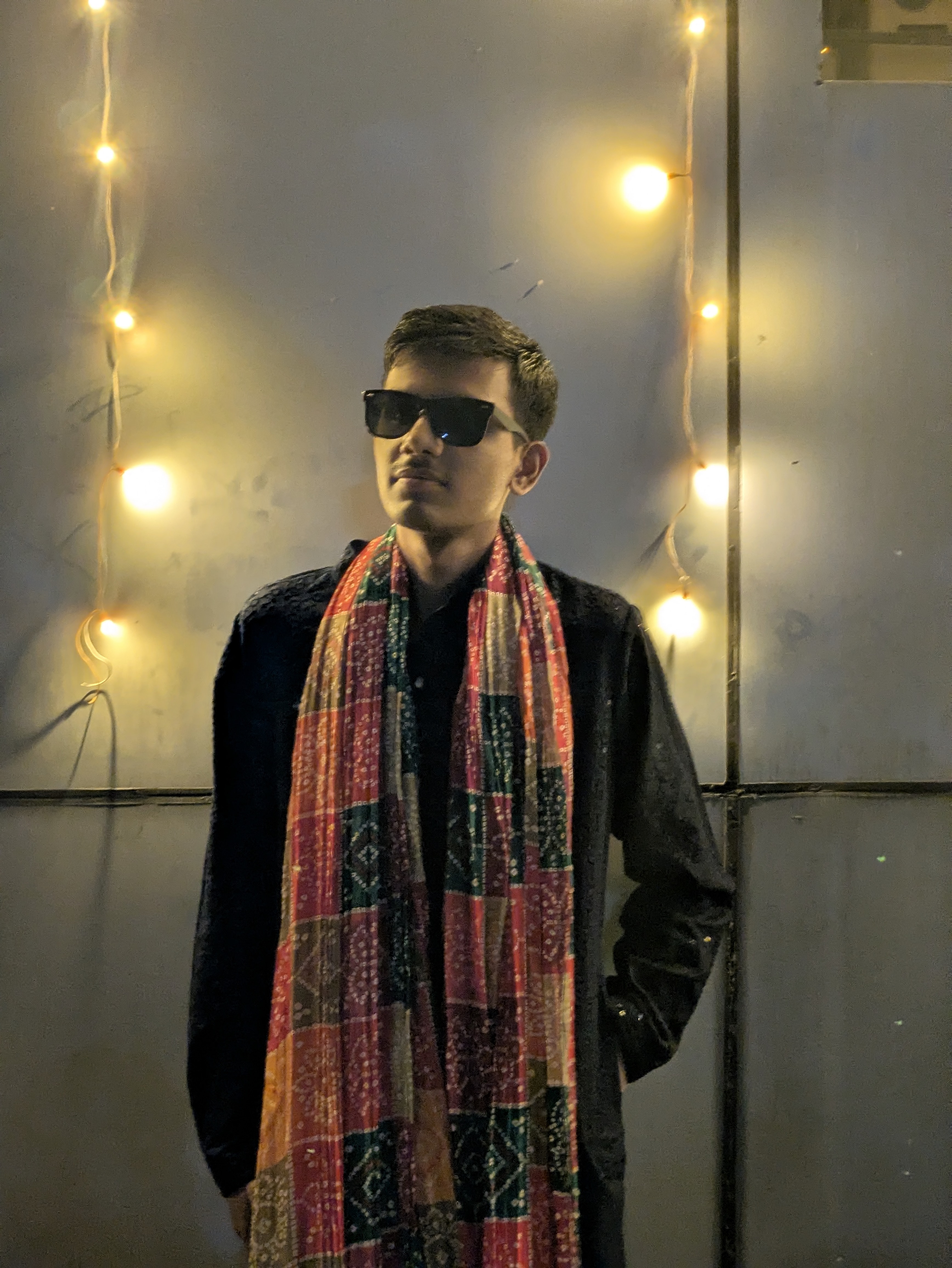 Mandeep Singh, AI/ML Engineer and Developer wearing sunglasses and a patterned scarf with atmospheric background lighting.
